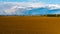 Dark rain clouds over hills, brown arable in foreground