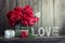 Dark red peonies in a decorated glass jar