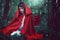 Dark red riding hood in a surreal forest