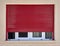 Dark red rolling shutters and white frame window on beige wall,