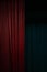 Dark red velvet curtain on one side of a black theatre stage, vertical event background with large copy space