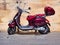 Dark Red Vespa Scooter parked Near Old Sandstone Wall