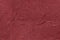 Dark red wavy background from a textile material. Fabric with fold texture closeup.