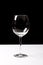 Dark red wine on a wineglass on a dark black background
