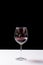 Dark red wine on a wineglass on a dark black background