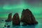 Dark rock against northern lights landscape with stars, starry sky with polar lights. Beautiful massive northern lights