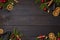 Dark rustic wood table flatlay - Christmas background with decoration and fir branch frame. Top view with free space for copy