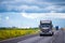 Dark semi truck with traffic on road in California