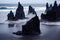 Dark sharp rocks protrude from water on iceland beach