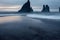 Dark sharp rocks protrude from water on iceland beach