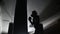 dark silhouette of a boxer girl practicing punches on a boxing bag.