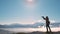 Dark silhouette of a hiker photographer taking picture of morning landscape in autumn mountains.