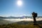 Dark silhouette of a hiker photographer taking picture of morning landscape in autumn mountains