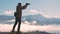 Dark silhouette of a hiker photographer taking picture of morning landscape in autumn mountains.