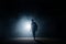 Dark silhouette of slim man walking on the street at night