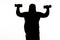 Dark silhouette of thick man training with weights