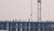Dark silhouette of tower crane and small silhouettes of workers at high residential apartment building construction site