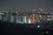 Dark silhouette of tower cranes at high residential apartment buildings construction site at night. Real estate