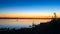 The dark silhouette of two lovers kissing in the water at night in the river on the horizon.