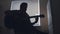 Dark silhouette of young attractive man musician composes music on the guitar and plays, silhouette