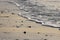 dark silhouetted rocks with rolling waves and sand