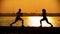 Dark silhouettes of couple knead leg muscles before the training on the seafront