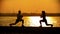 Dark silhouettes of people kneading leg muscles before the training on the seafront