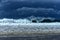 Dark skies with large shore breaking waves