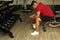 Dark-skinned Latino adult man suffers muscle fatigue, tiredness and extreme exhaustion of muscle from intense physical activity