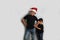 Dark-skinned Latino children, older brother in Santa hat takes care of his younger brother and spends time to celebrate Christmas