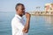 A dark-skinned man in his 40s blows a whistle against the backdrop of a seascape, close-up, selective focus. Work as a lifeguard o