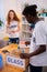 Dark-skinned teenager helping his friend sorting glass and plastic