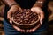 Dark skinned woman holding a bowl of coffee beans in her hands. Coffee harvesting concept