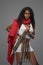Dark-skinnedn model in Greek-style tunic with red cape and ornate belt