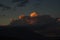 Dark sky with orange storm clouds over mountain range