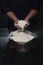 Dark space of white flour and hands chef in black suit uniform