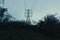 A dark spooky, moody edit. Looking up at an energy electricity pylon on a winters evening in the English countryside