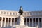 Dark statue and white building