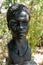 dark stone bust of African black woman. Lisbon botanical garden.