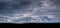 Dark storm clouds, wide panorama. Space,. Dark strip forest. Concept space