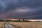 Dark, stormy clouds lit by the rays of the setting sun.