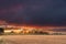 Dark, stormy clouds lit by the rays of the setting sun.