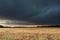 Dark, stormy clouds lit by the rays of the setting sun.