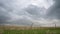 Dark stormy clouds over prairie with a barbed wire cattle fence