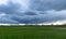 Dark stormy skies on a contrasting green field background