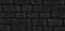 Dark textured background from ancient stone blocks. Stone wall pattern. Wide panoramic black background with space for design. Web