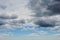 Dark thunderclouds are approaching the blue sky with white clouds. Change of weather from sunny to rainy. Dramatic skyscape