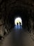 Dark Tunel with two people walking inside in the dark