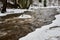 Dark water flowing fast in spring time in river