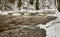 Dark water flowing fast in spring time in river in the creek